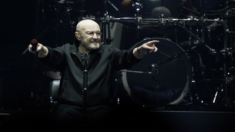 Phil Collins actuando sentado en el escenario