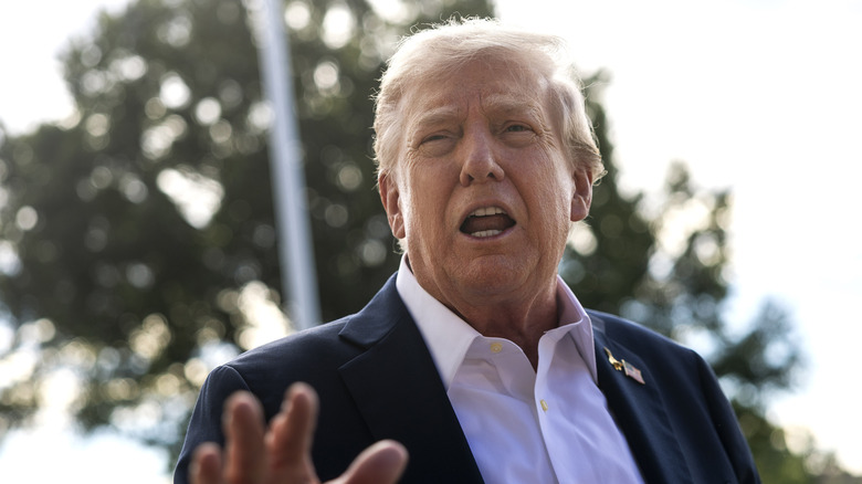 Donald Trump hablando con la prensa con el cuello de la camisa abierto