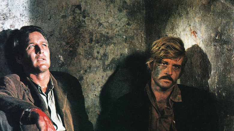 Paul Newman y Robert Redford apoyados en paredes en escena de la película