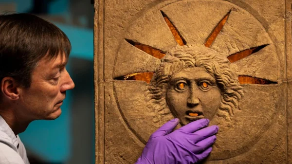 Conservador del Museo Nacional de Escocia examinando uno de los altares romanos de Mitra hallados en Inveresk, Escocia