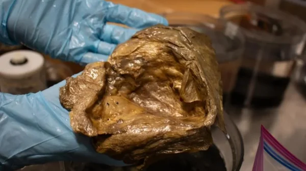 Un técnico sostiene el orbe dorado en el laboratorio del Smithsonian